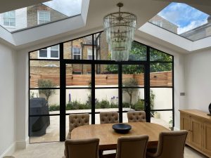 Steel lookbifold doors in classic style extension with chandelier